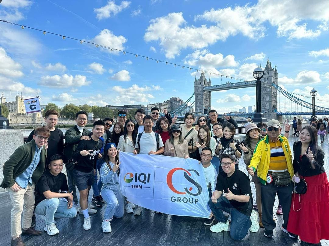 IQI CS Infinite 团队在伦敦塔桥与 IQI、CS 团队旗帜合照
